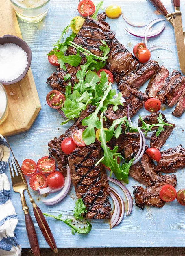 Asado con ensalada de tomate, cebolla y rúcula.