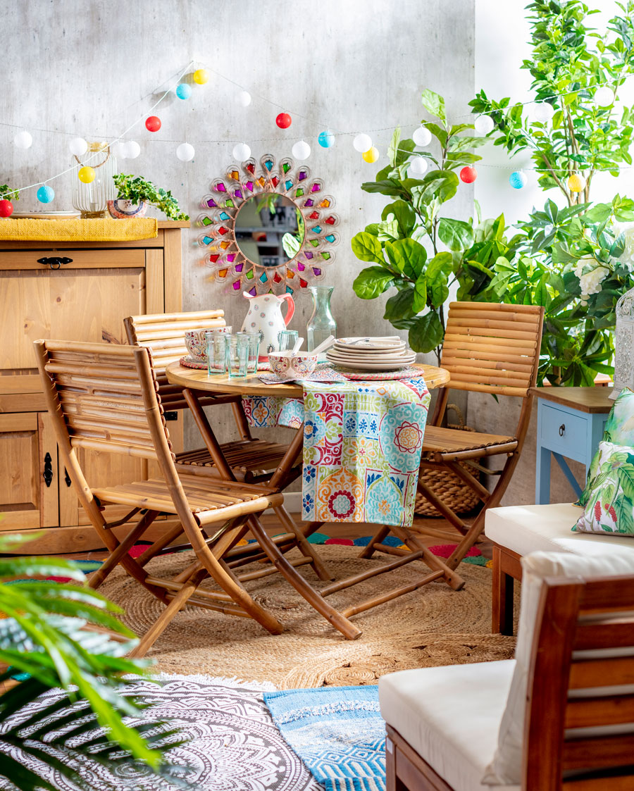 Mesa de terraza de fibras naturales estilo bamboo con vajilla de colores