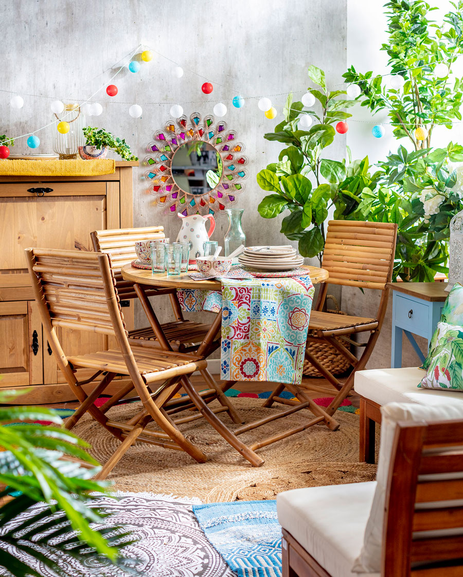 mesa exterior de madera con una planta de fondo