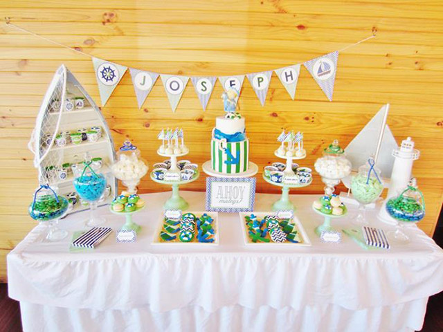 Buffet preparado para  cumpleaños de niño. La decoración es en estilo náutico, con cupcakes y galletas con forma de salvavidas y de anclas.