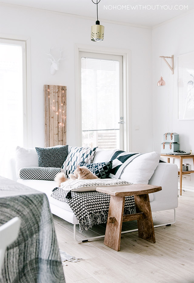 Sala de estar estilo escandinavo. Sofá blanco y cojines y textiles en tonos negros y blancos.