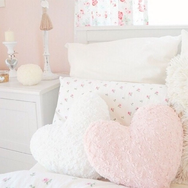 Cama de niña con cojines en forma de corazón en colores blanco y rosado