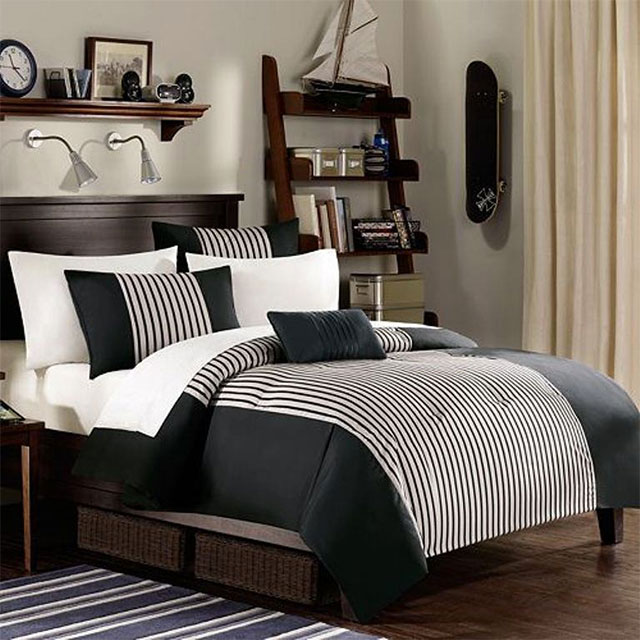 Dormitorio estilo masculino, ropa de cama en tonos blanco y negro, cortinas color crema, repisa de madera y skate negro colgado en la pared