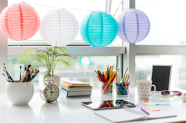 Escritorio creativo y lúdico con lamparitas de papel de colores.