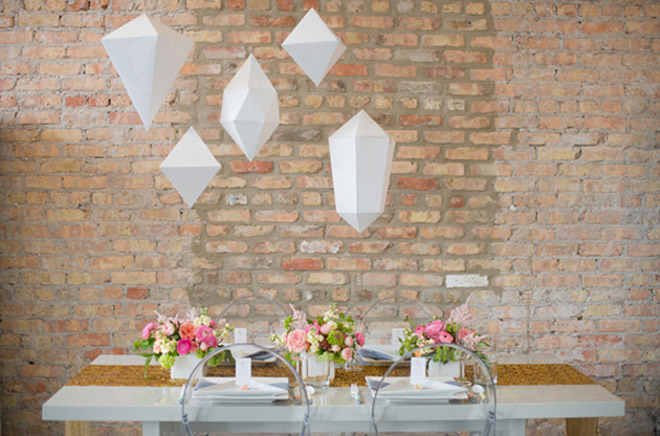 Decoración de matrimonio con colgantes blancos de figuras geométricas.