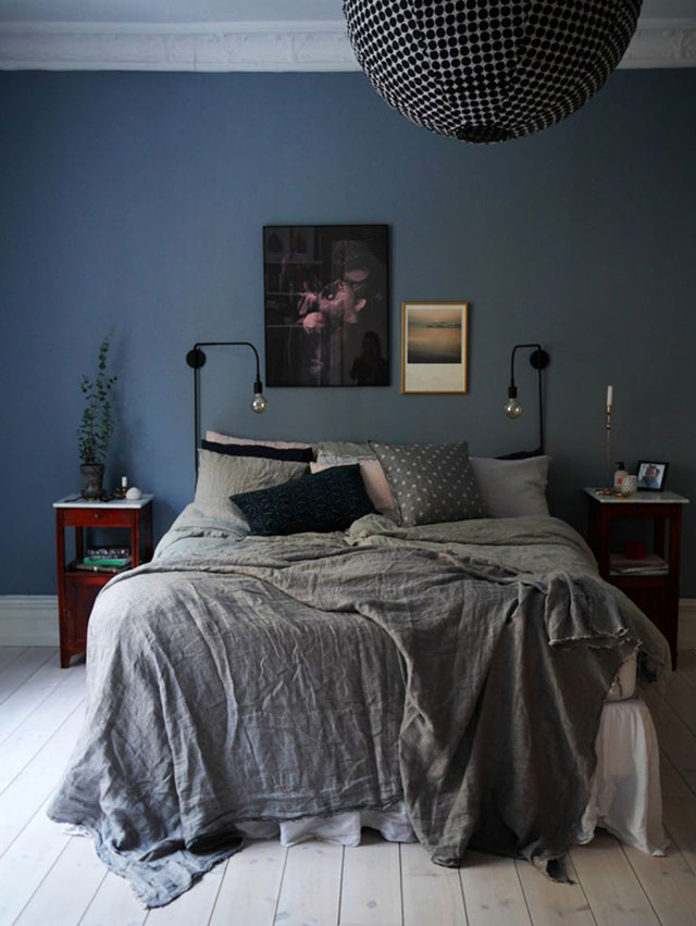 Dormitorio con muros color azul piedra, cama con mantas de lino en gris azulado.