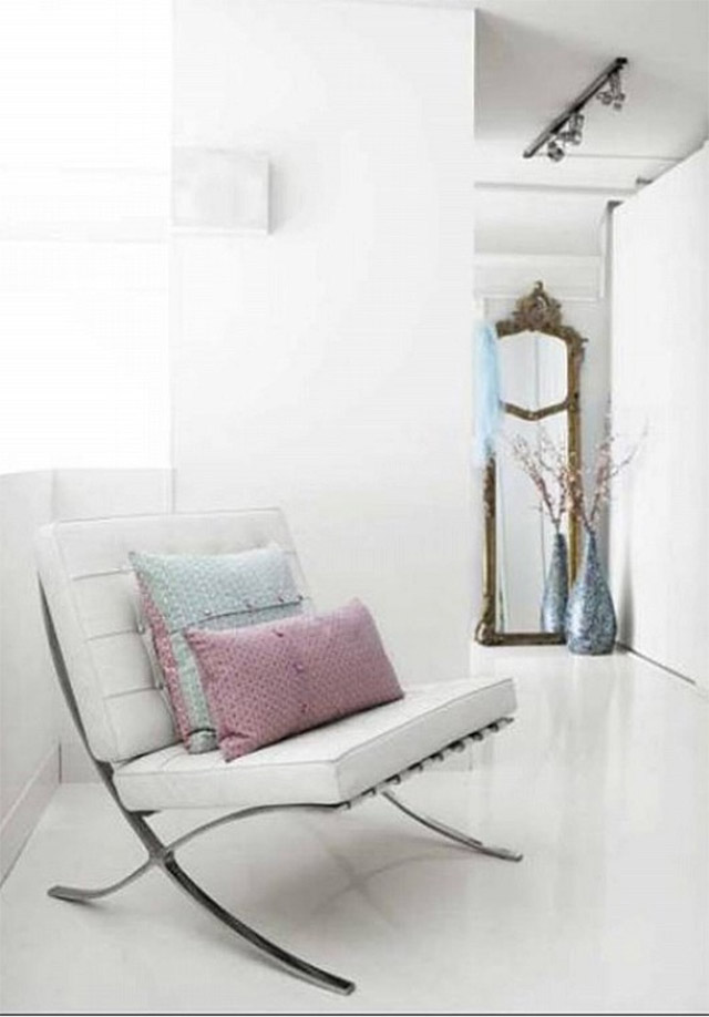 Silla Barcelona blanca con cojines de lana en rosa y celeste, en el hall de entrada.