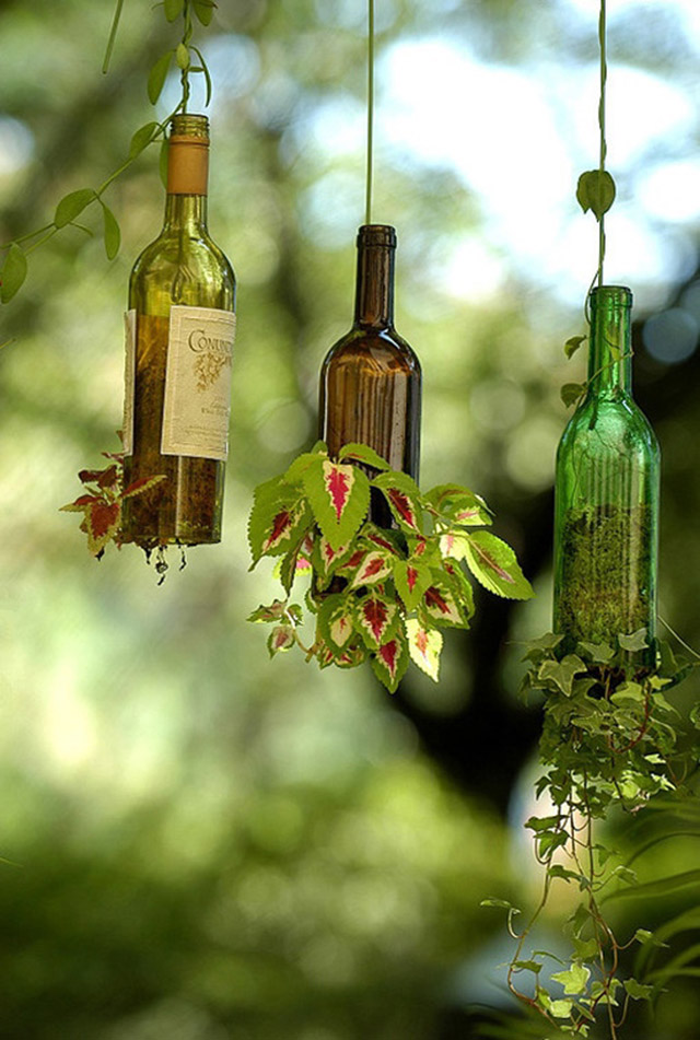 Maceteros colgantes realizados con botellas de vidrio.