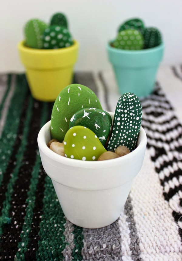 Macetas de colores con catus hechos de piedras pintadas.