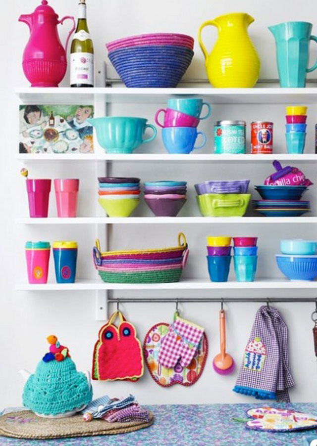 Repisas con variedad de jarrones, frascos, tazas, platos, bowls, canastos de rafia, paños de cocina, toma ollas, todos en diversos colores como el amarillo, calipso, fucsia o verde, y distintos materiales.