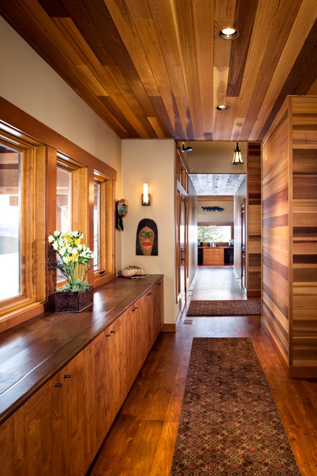 Vista de hall con muebles, cielo, piso y paredes con enchapado de madera.