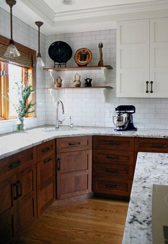 Cocina con intervención de madera en las puertas de los muebles de cocina, marco de ventana y repisas junto al lavaplatos.