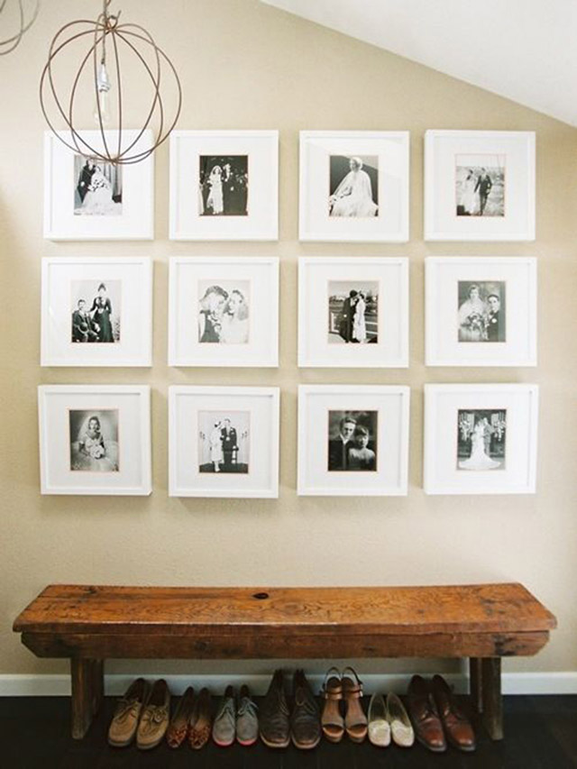 Banqueta de madera color natural, sobre la banqueta una galería de fotografías den blanco y negro, bajo la banqueta varios pares de zapatos.